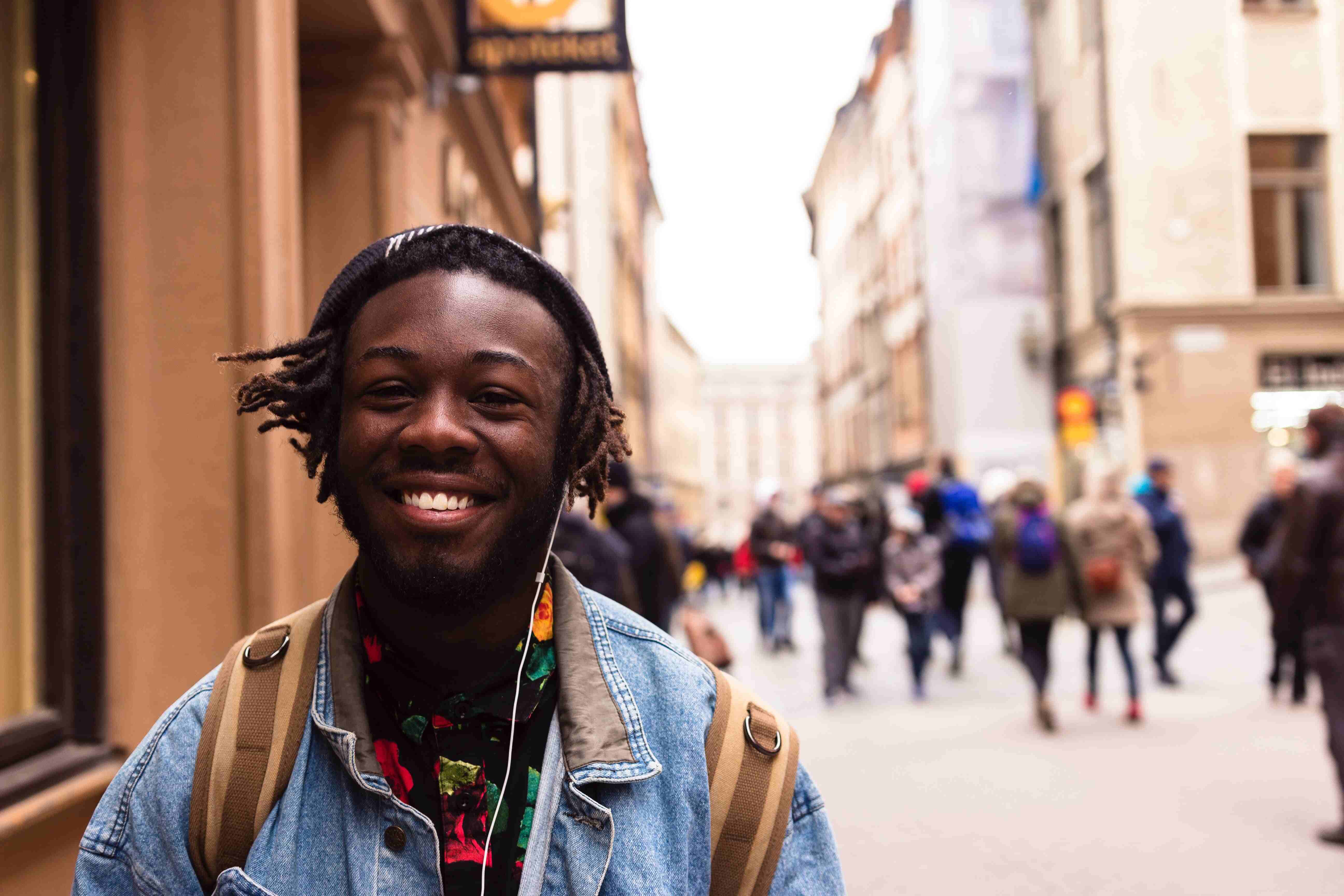 a black man smiling on the street